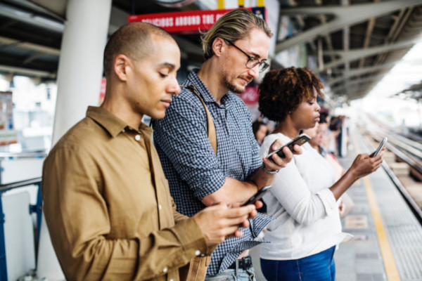 three people staring at their smartphones